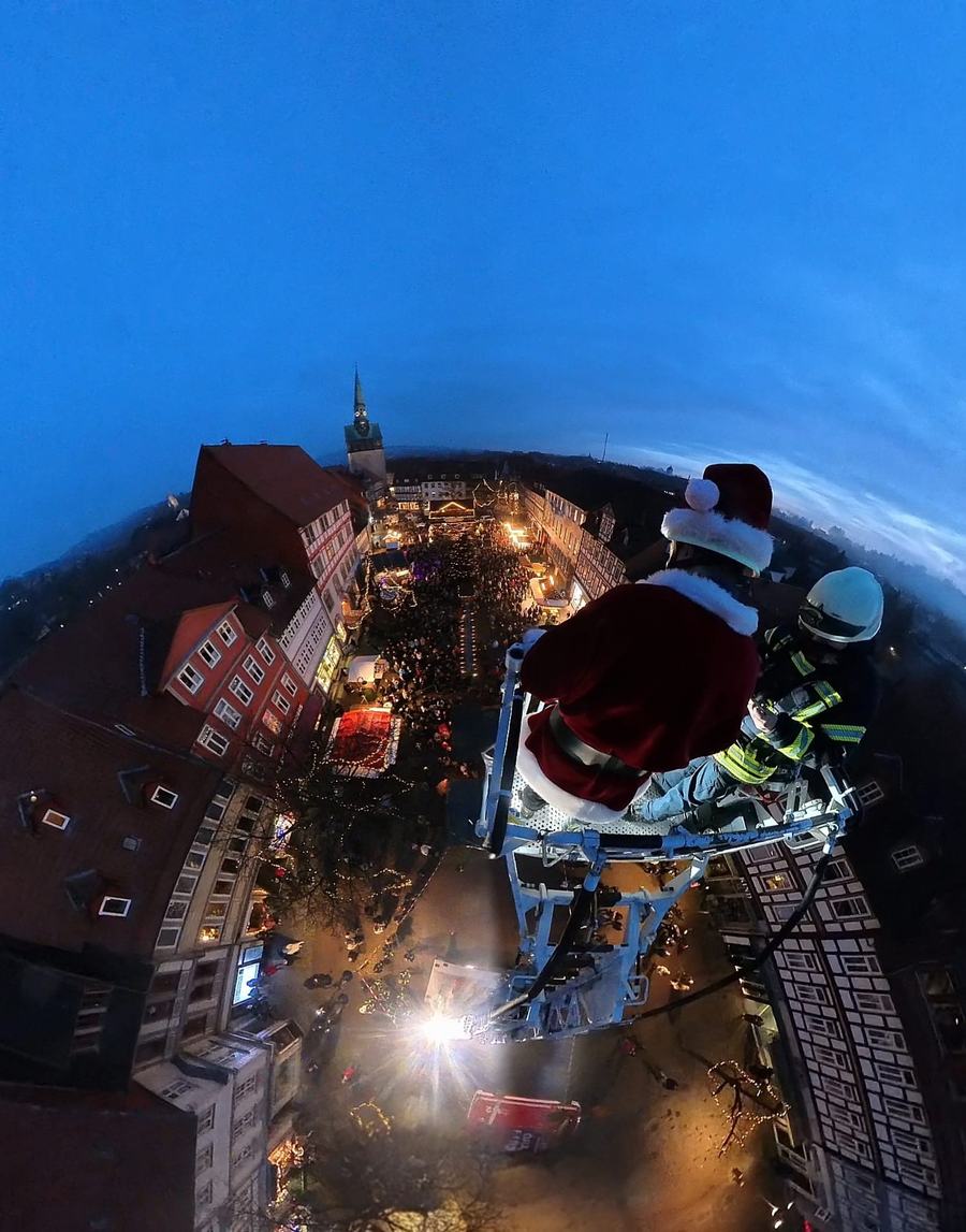 Der Weihnachtsmann im Feuerwehrkorb über dem vollen Kornmarkt
